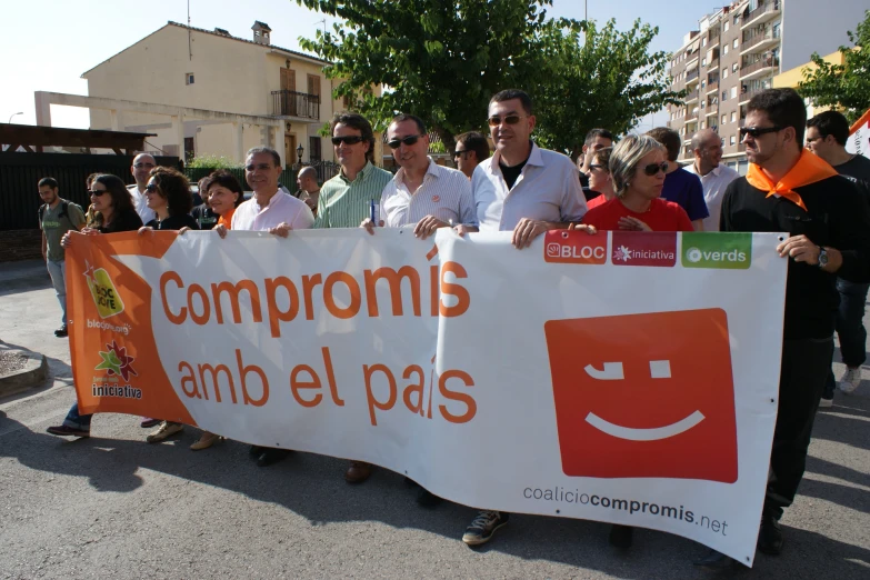 several people are holding up an orange and white sign