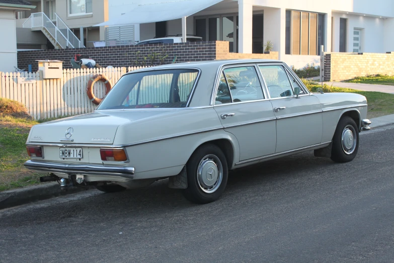 an old, gray, older model car parked along a street