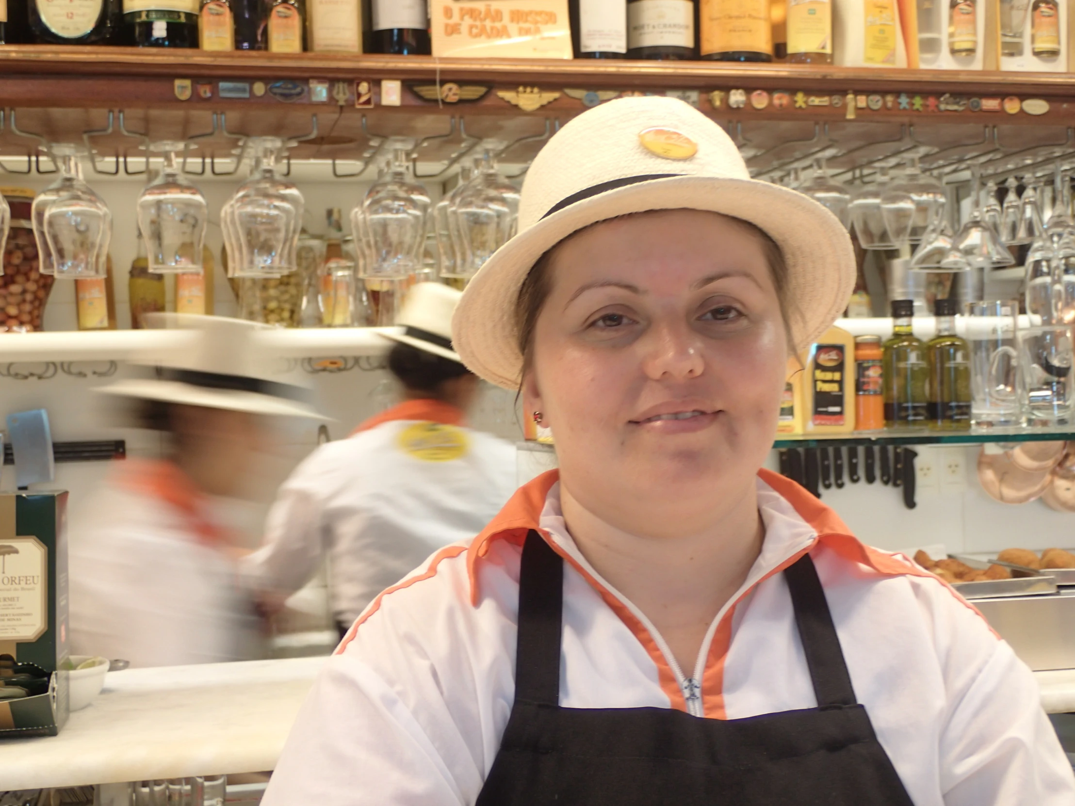 a woman with an apron and hat in front of a bar