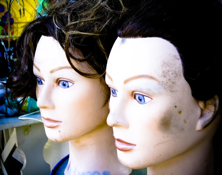 three mannequin heads are shown with bright blue eyes