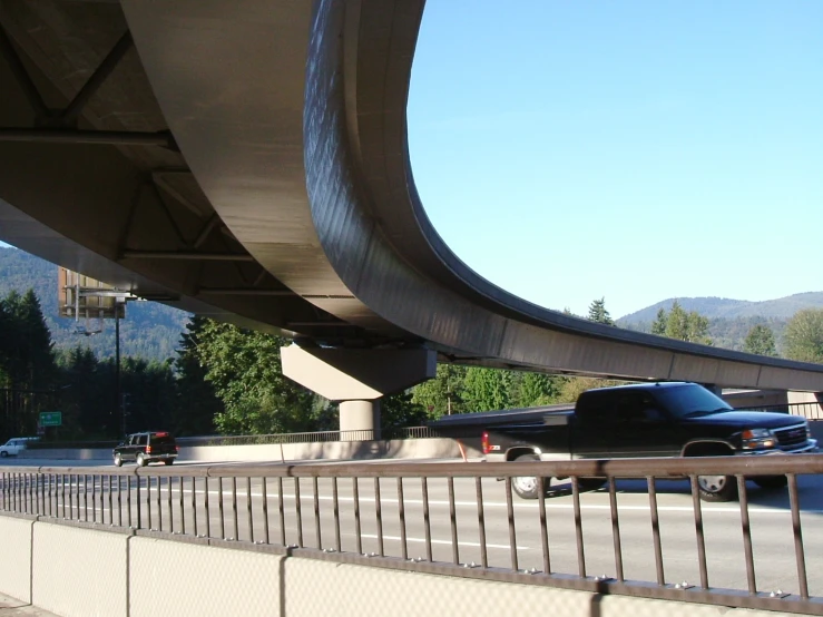 the cars are traveling under a bridge in the city