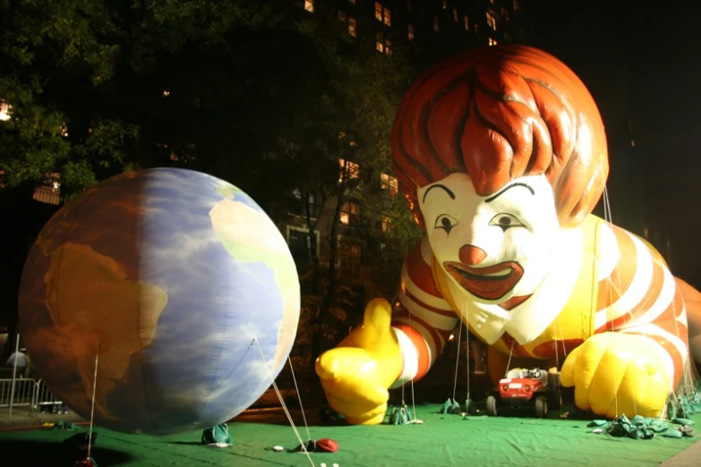 inflatable clown balloon floats near a blue ball