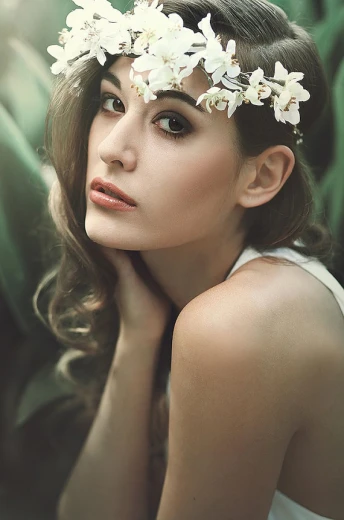 a woman with a flower crown is posing for the camera