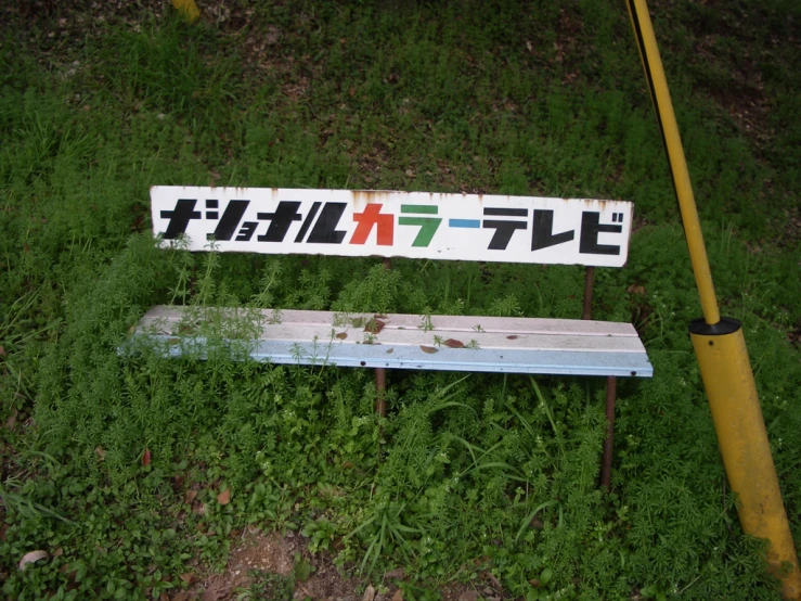 a bench sitting in the middle of a green grass covered field