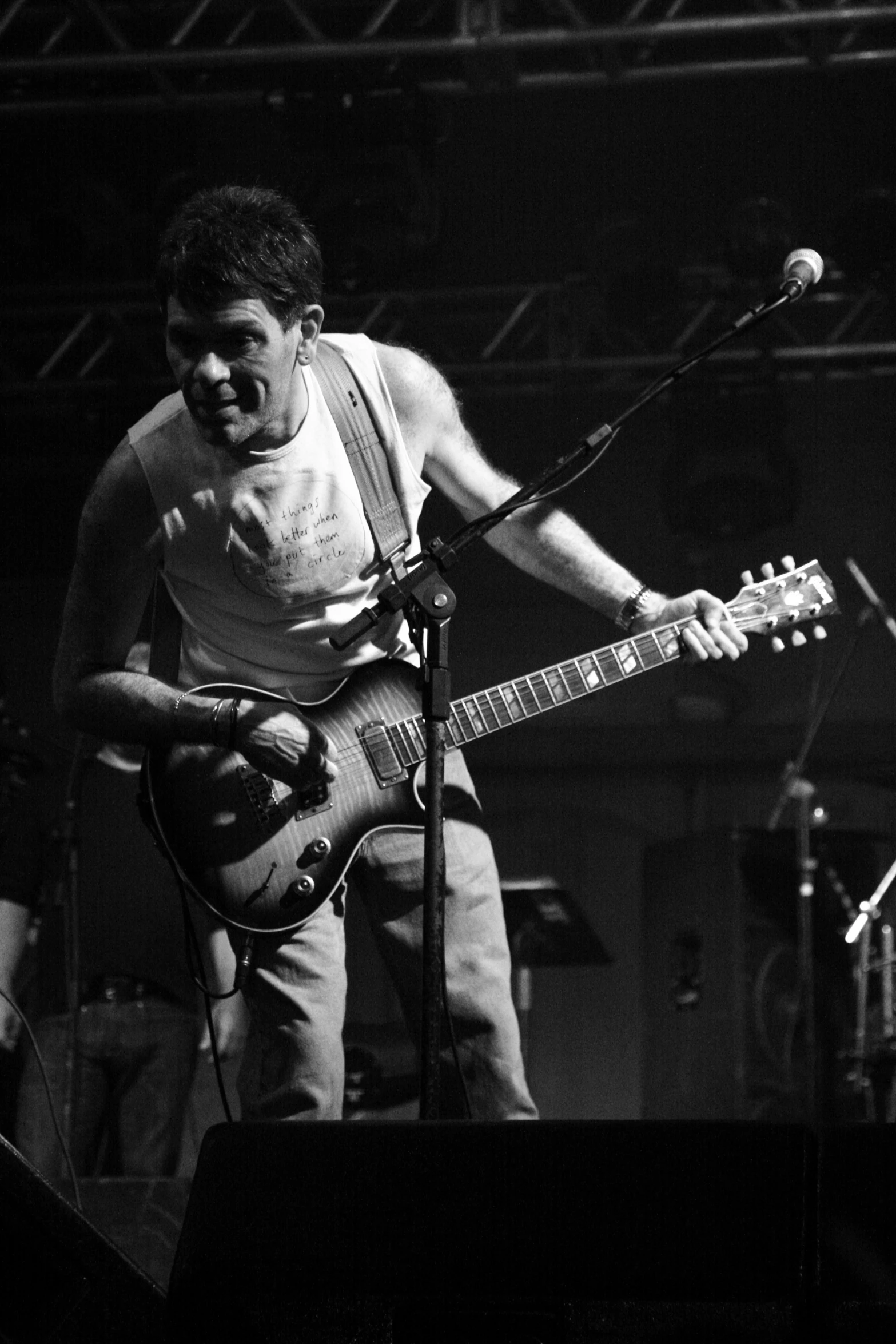 a man standing on a stage playing a guitar