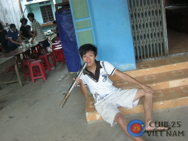 a man with a baseball bat posing on a porch