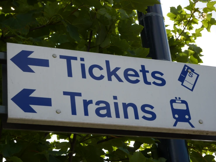 a street sign displays two locations where there is a ticket booth