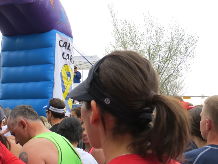 the crowd is standing near the blue and purple inflatable ballon