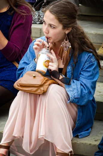 a woman is sitting down and drinking from a beverage
