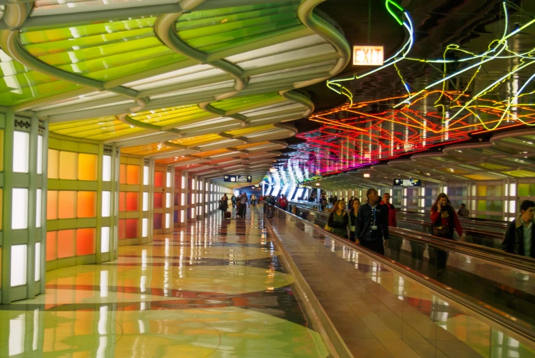 many people stand in a colorfully colored subway