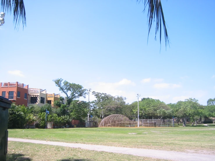 a park and house near a sidewalk that is in grass