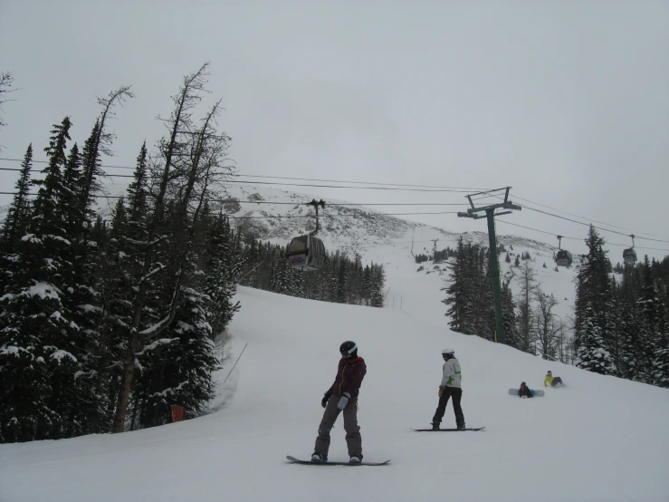 three skiers on a snow covered mountain side