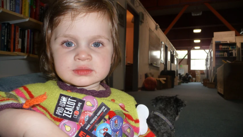 a small child wearing a shirt with cars and logos on it