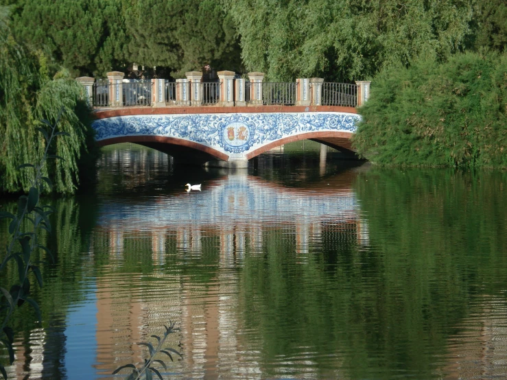 there is an artistic blue and white bridge over the water