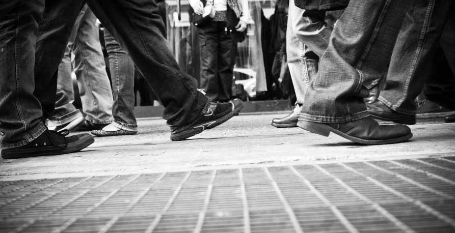 people's feet on a sidewalk in front of them