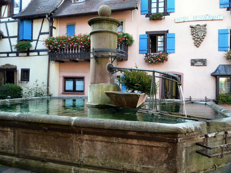 a very big pretty fountain with plants by it