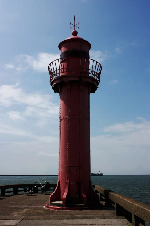 a tall red light tower with an ornate top