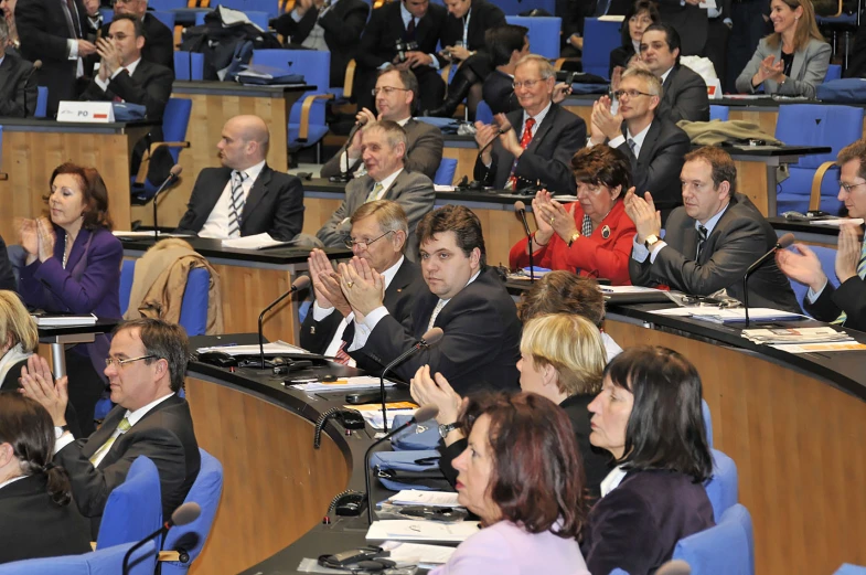 many people sitting in rows in a conference room