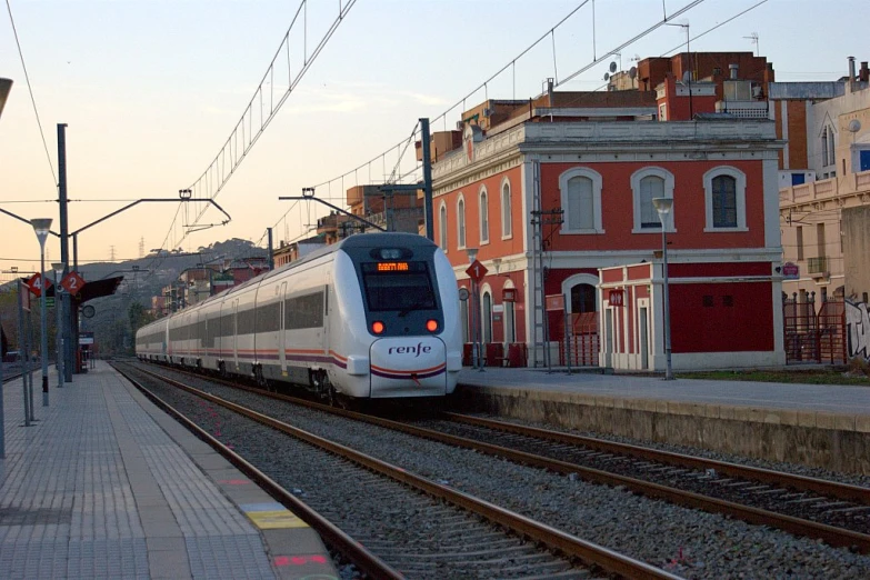 a train pulling into a train station next to buildings