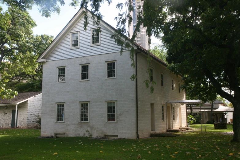 a big building sits in the back yard of a white house