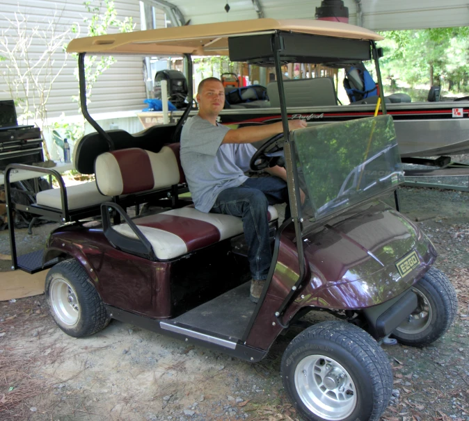 a person sitting in a golf cart with a big golf bag on it