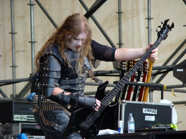 a man dressed up as a demon playing an electric guitar