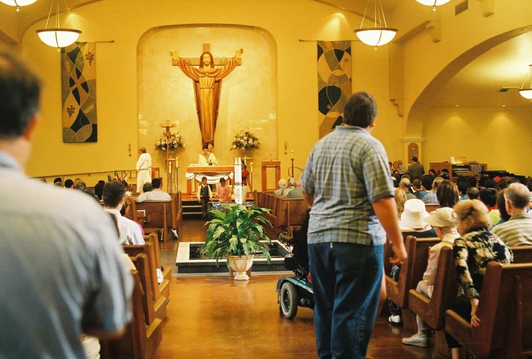 people in church with a crucifix and people standing at the alter