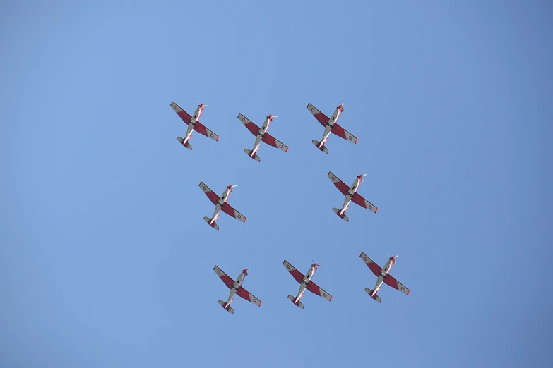 a group of planes in formation and flying against the sky