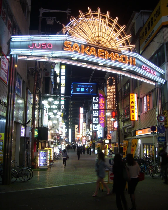 people walking under the neon lights in an asian shopping district