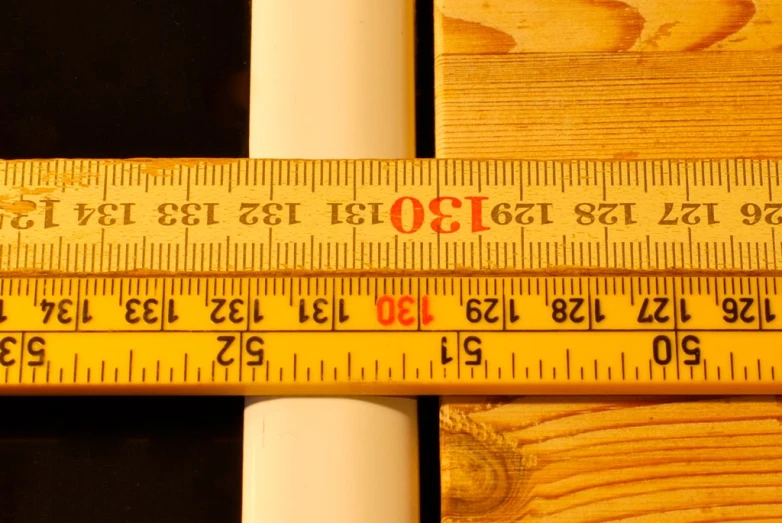 a measuring tape next to a wooden plank