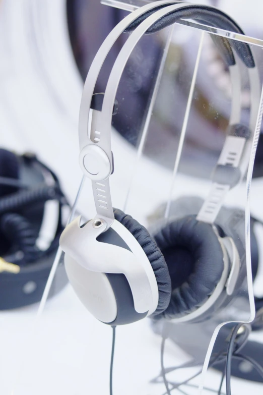 white headphones hanging on a metal rack