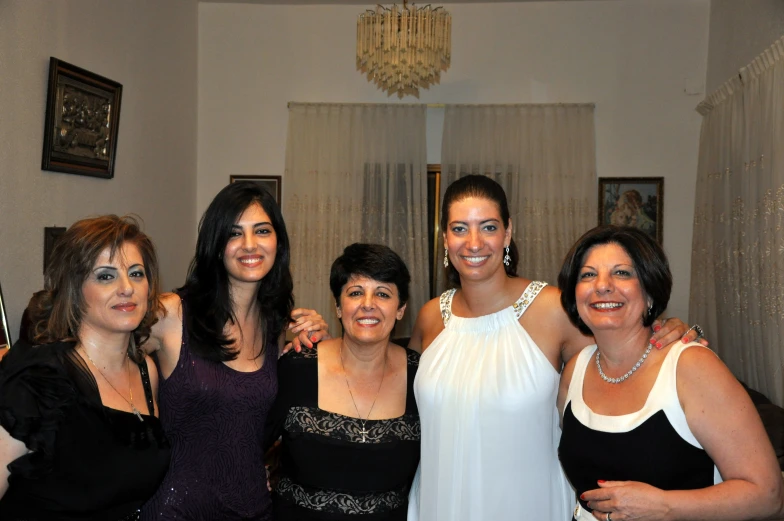 five ladies are posing together in an apartment