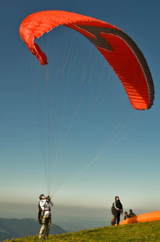 some people on a hill flying kites in the air