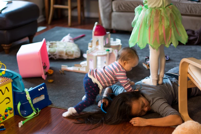 a baby is playing with her mom on the floor