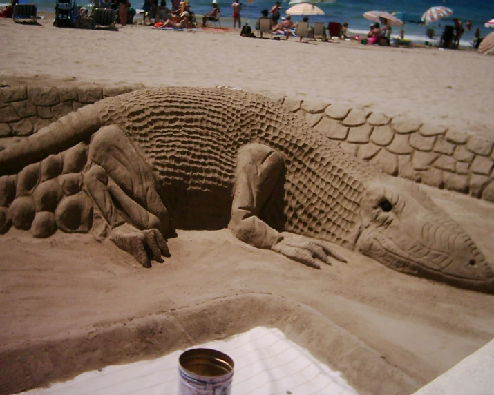 a large sand sculpture is sitting on a beach
