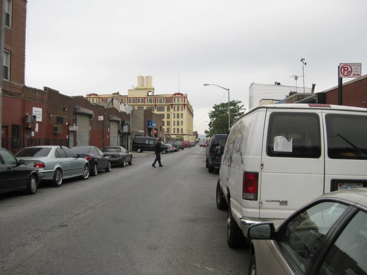 a white van parked next to a row of parked cars