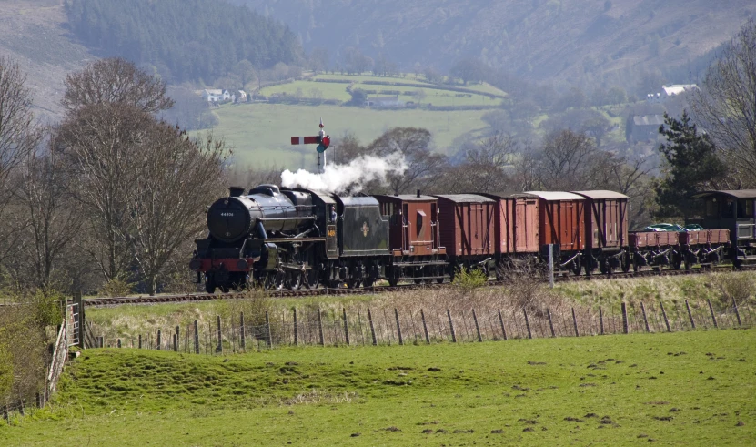 an old fashioned steam engine on the railroad tracks