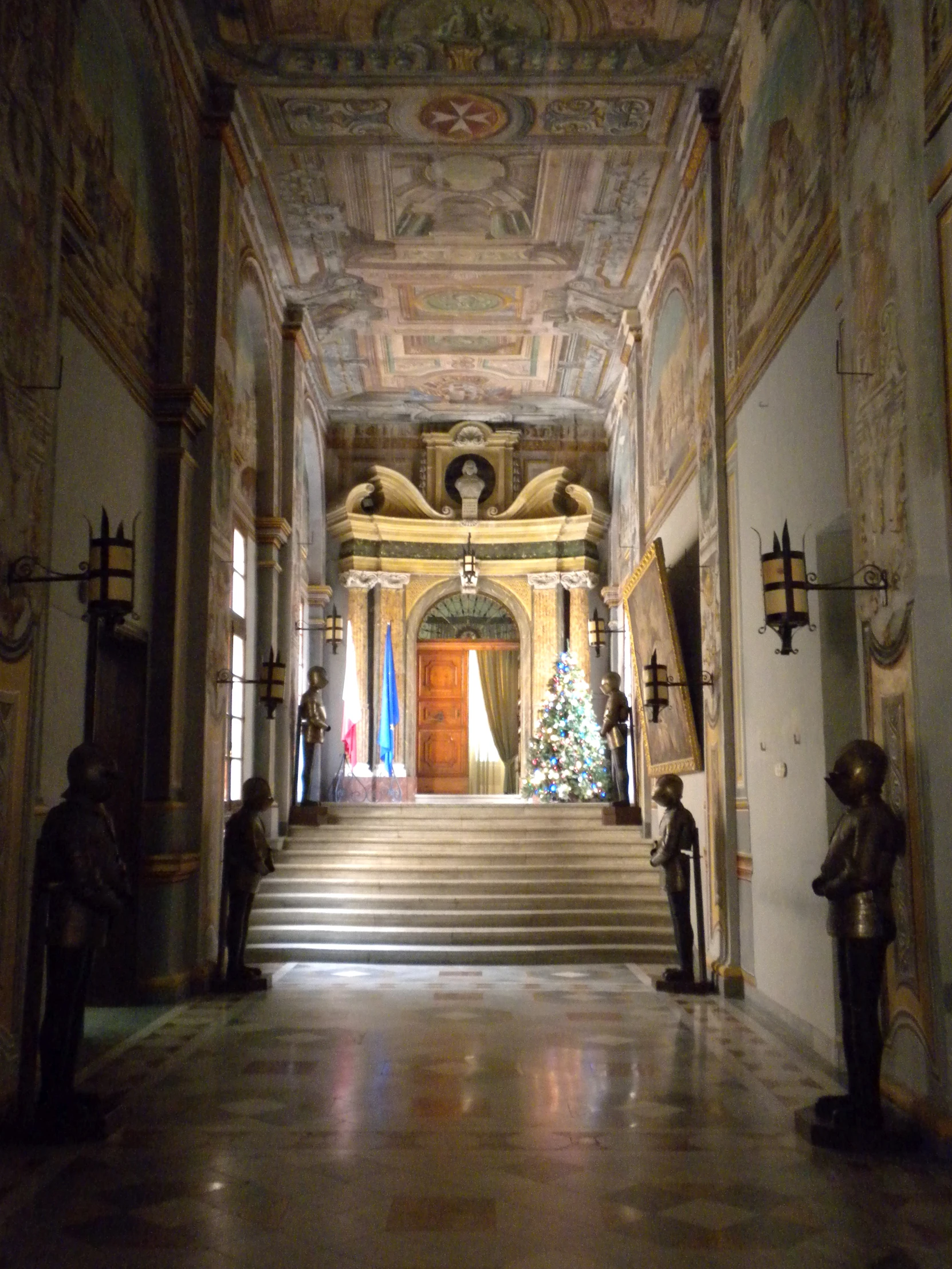 a long hall with several stairs, with paintings and christmas trees