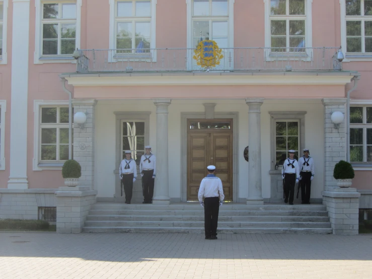 five police officers standing in front of a large building