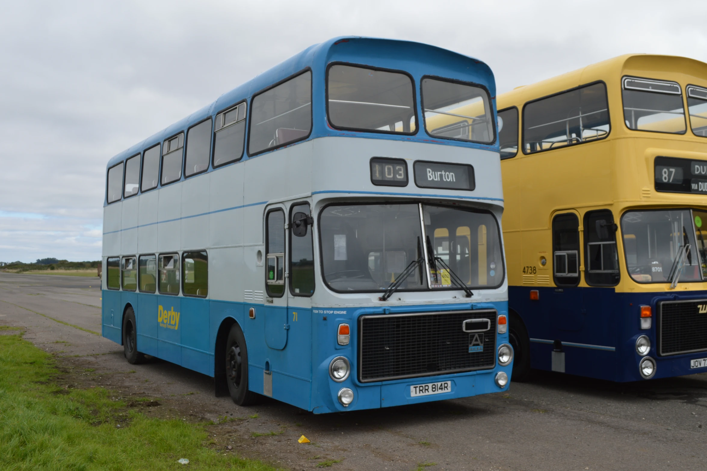 a yellow and blue double decker bus in the street