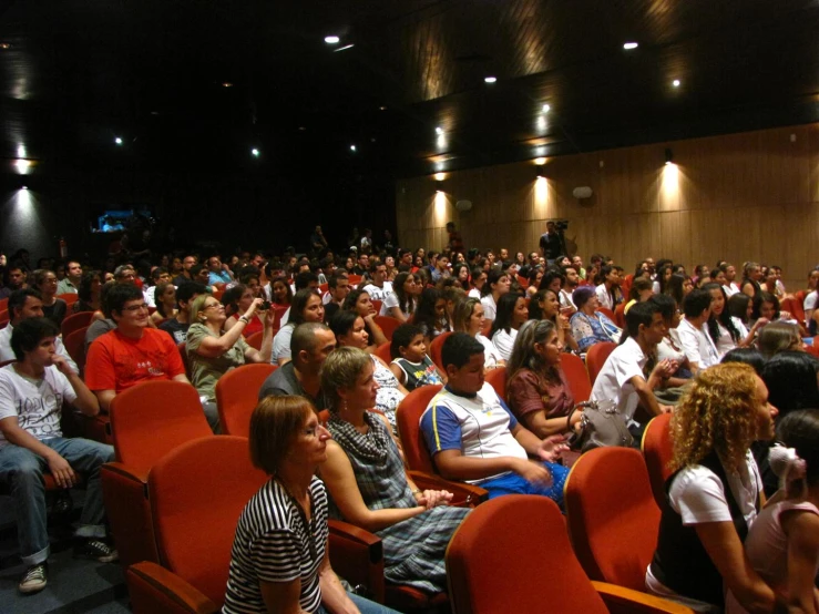 people are gathered together in rows for an auditorium