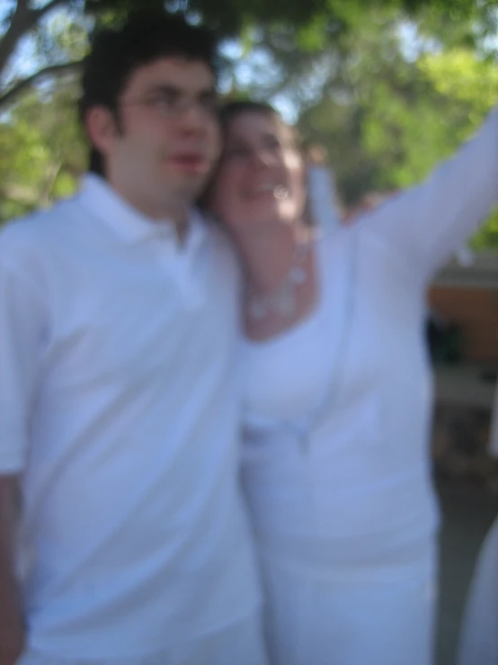 a couple who are all dressed in white posing for a po