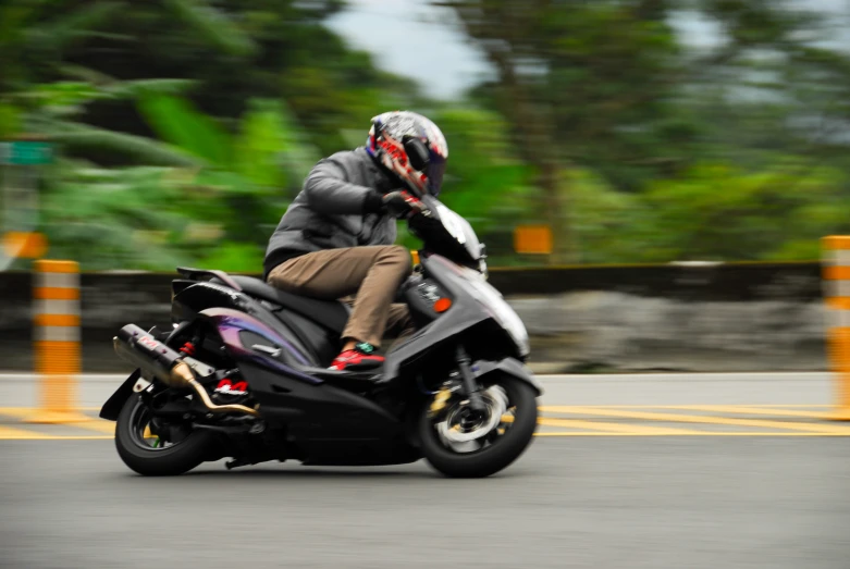 a man in a gray jacket and helmet riding a motor cycle