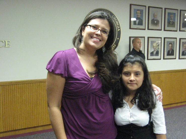 two people are posing for a picture in an office building