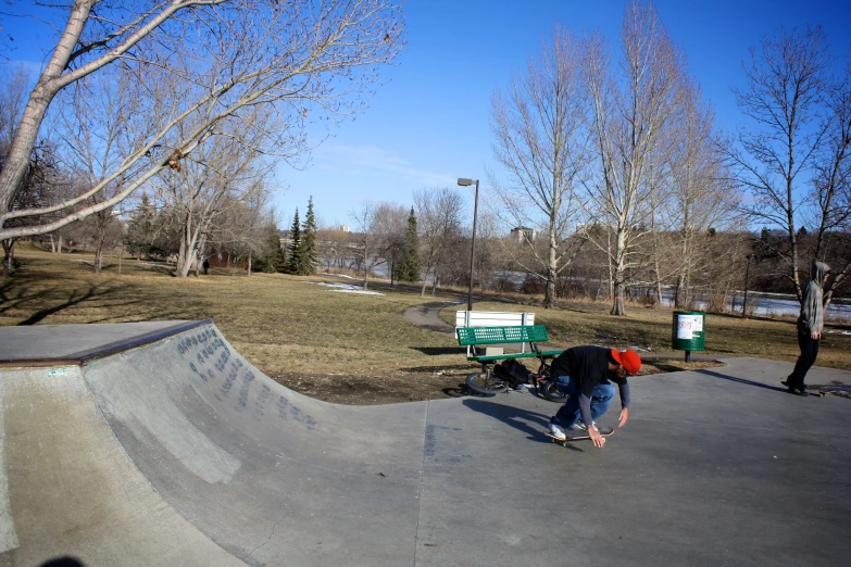 a skateboarder on the edge of a halfpipe in a park