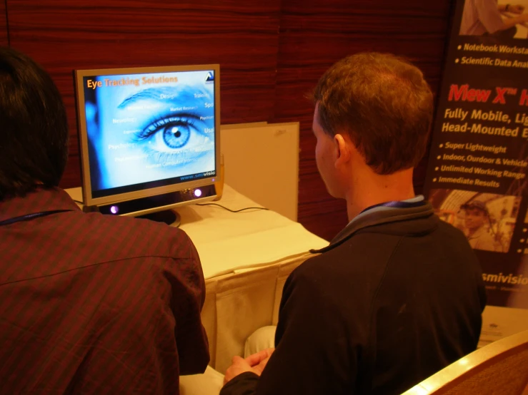 two men are watching the web in front of a television screen