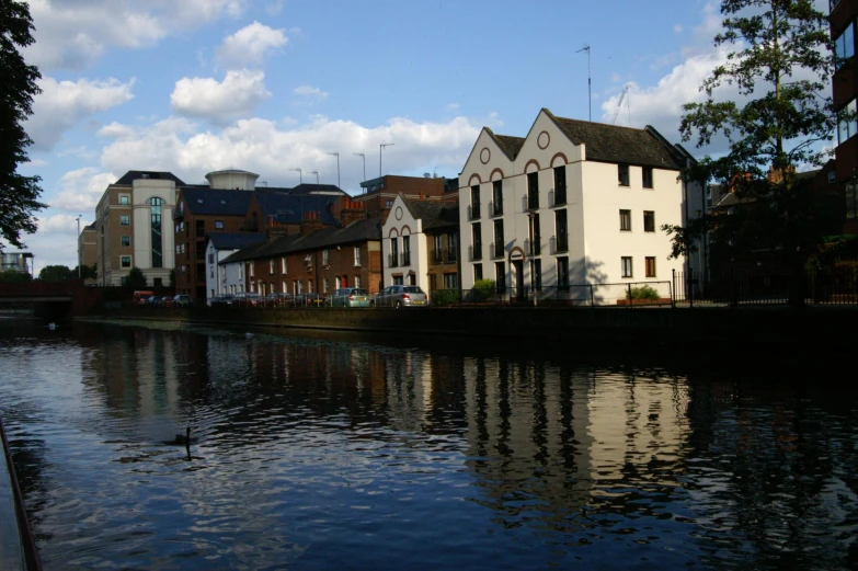 a water way that has buildings and a few ducks swimming in it