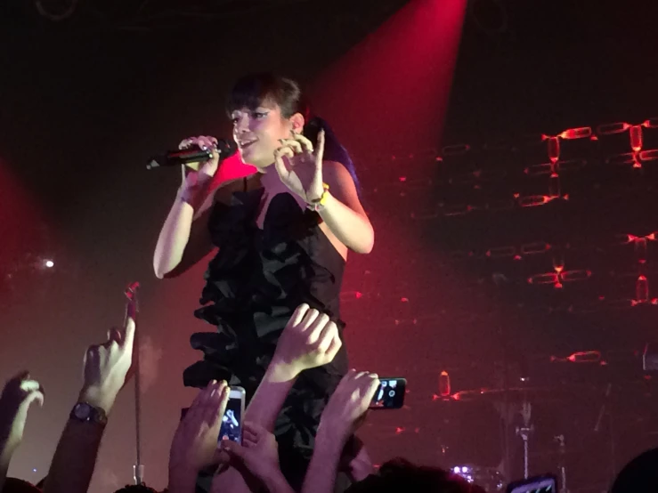 a lady on stage with a microphone in her hand