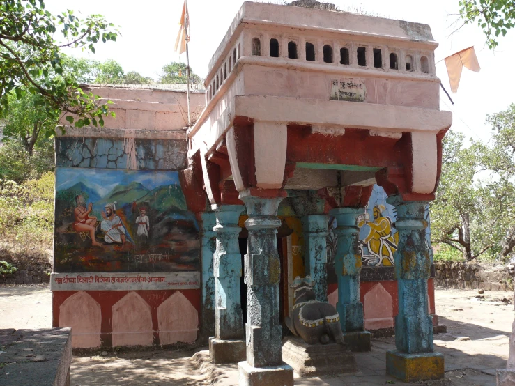 a painted building in a park with columns