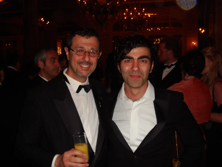 two men in tuxedos standing next to each other